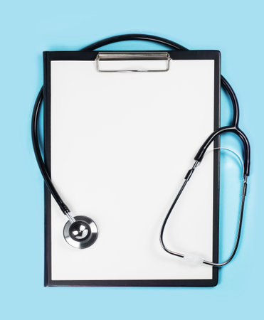 Blank medical clipboard with stethoscope on blue background concept. Copy spaceの写真素材