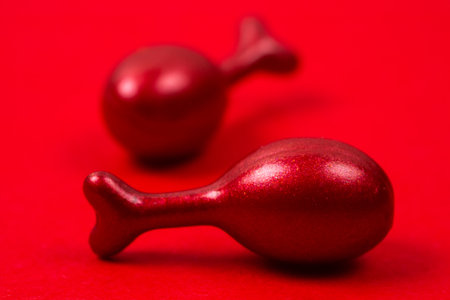 Red capsules with cosmetic oil for the face on red background.の写真素材