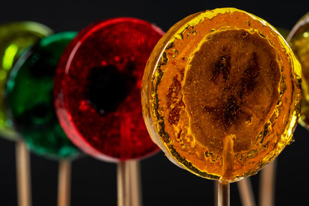 Sweet colorful lollipops with dried fruits on black background.の写真素材