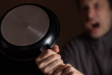 Photo of crazy angry mad outraged man holding kitchen pan.の写真素材