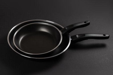 Two black frying pan on dark background, close-upの写真素材