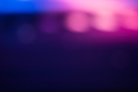 Blur color flare. Neon glow background. Bokeh radiance reflection. Defocused fluorescent blue pink light gleam on dark abstract overlay.の写真素材