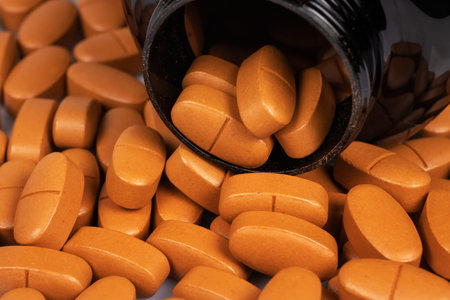 Brown pills spilling out of pill bottle. Brown pills medicine