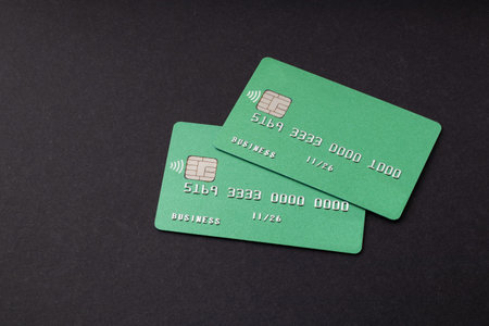 Two green credit cards on dark background