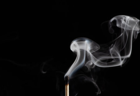 Smoke from a match that was just put out, isolated on black background.