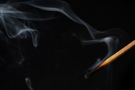 Smoke from a match that was just put out, isolated on black background.の写真素材