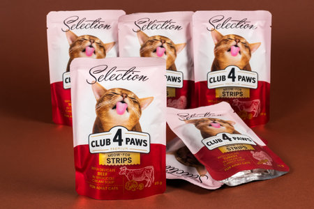 Dnipro, Ukraine - August 18, 2023: Club 4 Paws Premium Selection cat food on brown background. Cat food as background.のeditorial素材