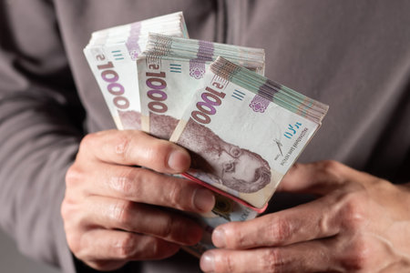 Man holding Ukrainian money 1000 hryvnia banknotes. closeup.