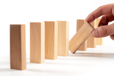 Close up of man hand planning, risk and strategy in business. Businessman gambling placing wooden block on a tower with copy spaceの写真素材
