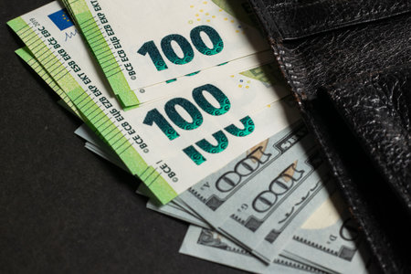 Cash of 100 dollar and 100 euro note, in wallet. Lot of one hundred dollar bills close-up. dollars in wallet.の写真素材