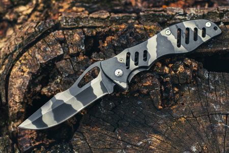 Folding knife on wooden background. EDC knife