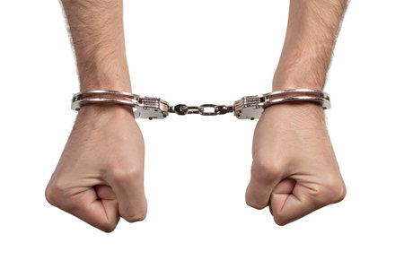 Man's hands in handcuffs on a white background, isolated.の写真素材