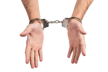 Man's hands in handcuffs on a white background, isolated.