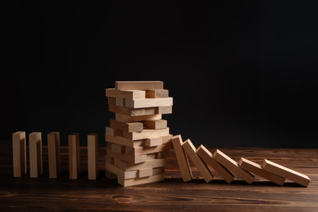 Falling wooden block game stick from falling domino concepts of financial risk management and strategic planning.の写真素材