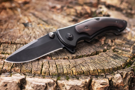 Folding knife on wooden background.の写真素材