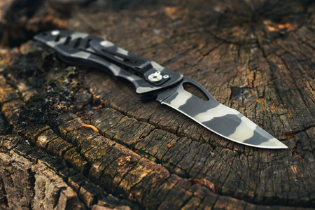 Folding knife on wooden background.の写真素材