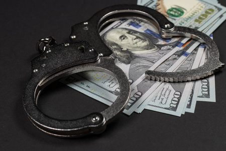American dollars and handcuffs, Concept of ideas of corruption, dirty money or financial crimes.の写真素材