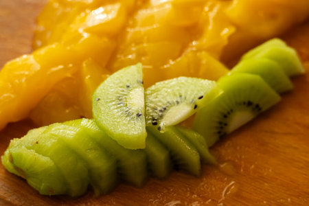 slices of kiwi and slice mango on the desk.の写真素材
