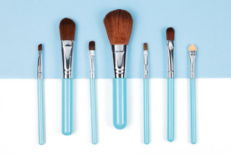 Set of makeup brushes on blue and white colored composed background. Top view point, flat layの写真素材