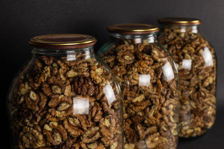 The walnut kernels in jar isolated on dark background