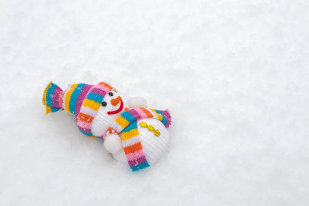 A fabric snowman in a scarf and hat on the snow in winter,の写真素材