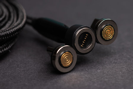 Magnetic charger wire for phone on dark background.