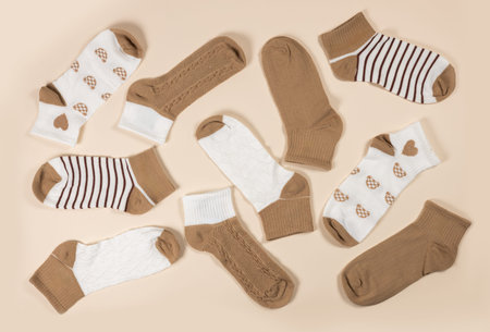 Multi-colored socks on a beige background. View from above. Many different socks for cold seasons....