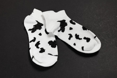 black and white socks on a dark background. View from above. Many different socks for cold seasons. Socks are scattered on a bright background.の写真素材
