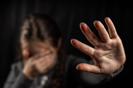 Crying teenage girl showing a stop sign with her hand.の写真素材