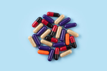 Heap of colorful medicine pills on blue background.の写真素材