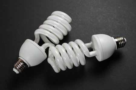 Energy saving fluorescent light bulb on dark background.の写真素材