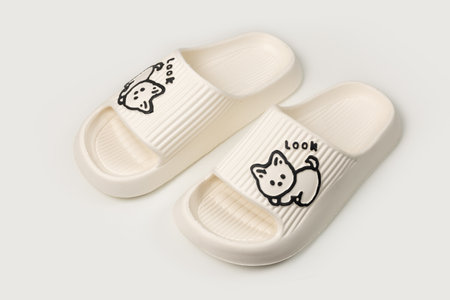 Pair of rubber slippers on beige background.の写真素材