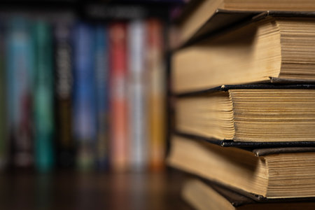 Book stack in the library room and blurred bookshelf for business and education background, back to school concept.の写真素材