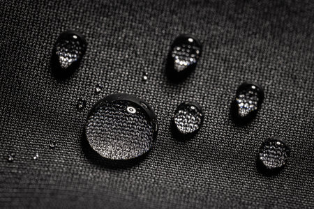 Water drops on waterproof black fabric.