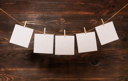 paper cards hanging on the rope on wooden background.の写真素材