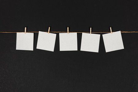 clothespin hanging with blank paper on dark background.の写真素材