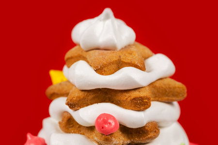 gingerbread cookie of green Christmas Tree on red background. Traditional Christmas food. Christmas and New Year holiday concept. Copyspace.の写真素材
