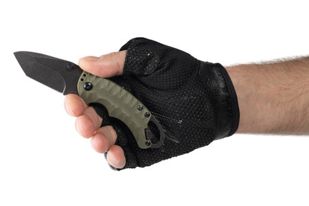 Hand in tactical glove, holding folding knife, on white background.の写真素材