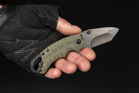 The man tactical gloves using folding knife.の写真素材