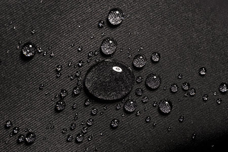 Water drops on waterproof black fabric.