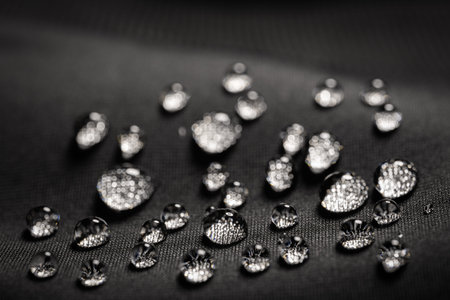 Water drops on waterproof black fabric.
