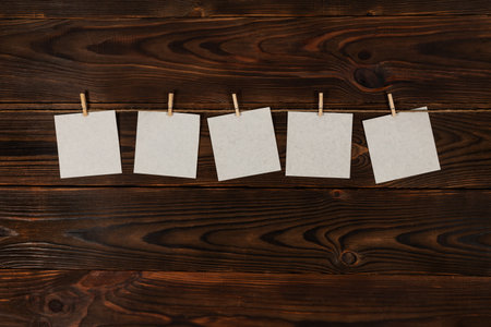 paper cards hanging on the rope on wooden background.