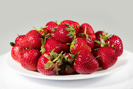 Fresh ripe delicious strawberries in a white plate on a white background.の写真素材