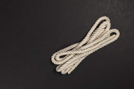 beige rope on dark background close up.