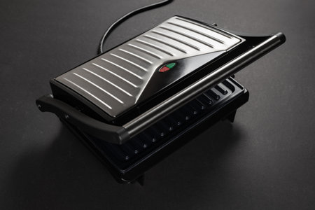 Modern electric grill on dark background.の写真素材
