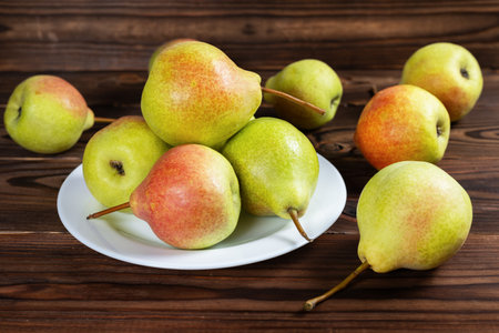 Fresh pear fruit on plate with wooden table, Healthy fruit.の写真素材