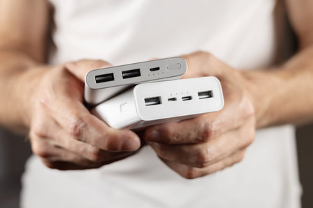 Two powerbanks in hand. Power bank for charging mobile devices. Smart phone charger with power bank....
