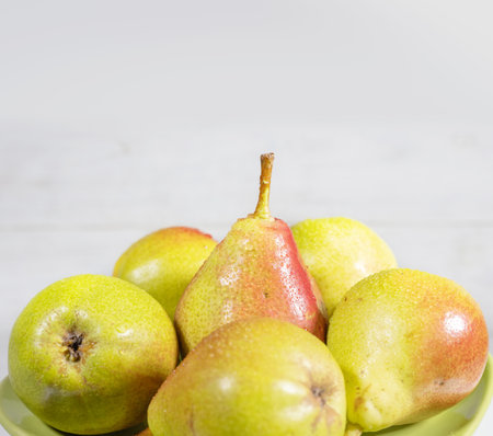 Ripe pears with water drops on white wooden table.の写真素材