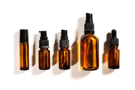 Amber glass bottles for cosmetics, natural medicine or essential oils isolated on a white...