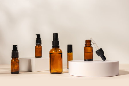 Amber cosmetic bottle with pipette on white podium, product packaging, anti aging serum with peptides, cosmetics mockup, spa conceptの写真素材